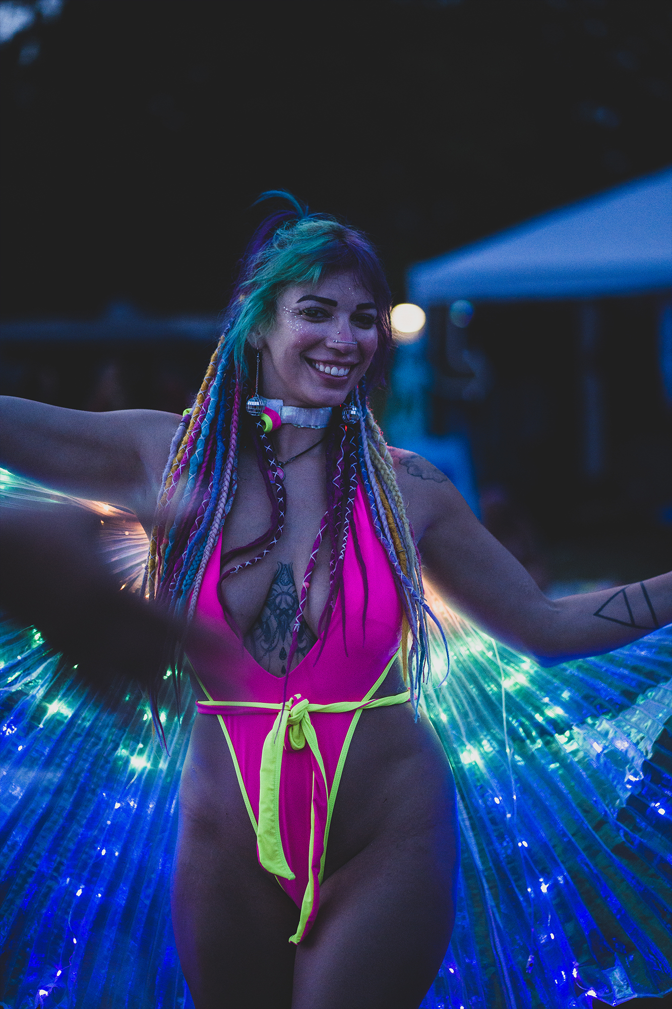 Smiling adult event guest dancing under colorful lights after dark