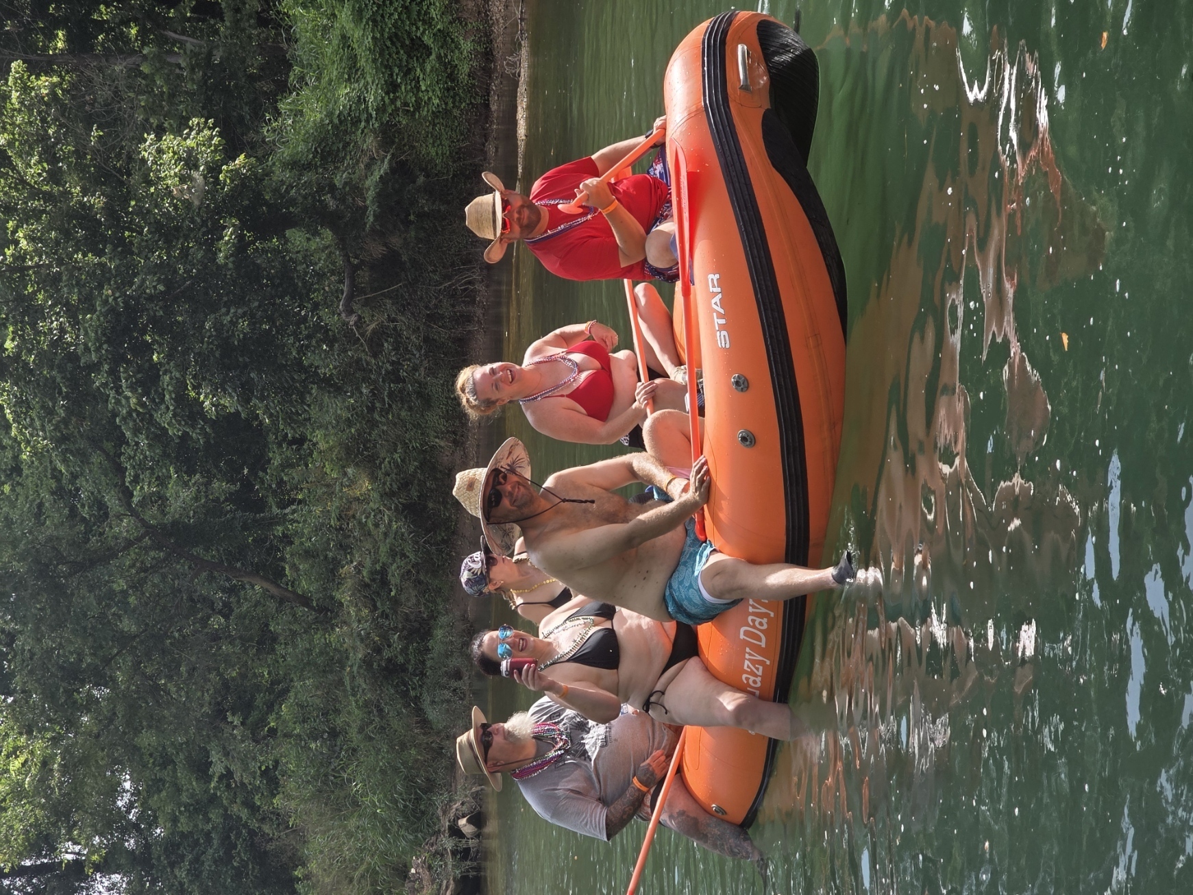 OTB guests laughing together on a raft during the float